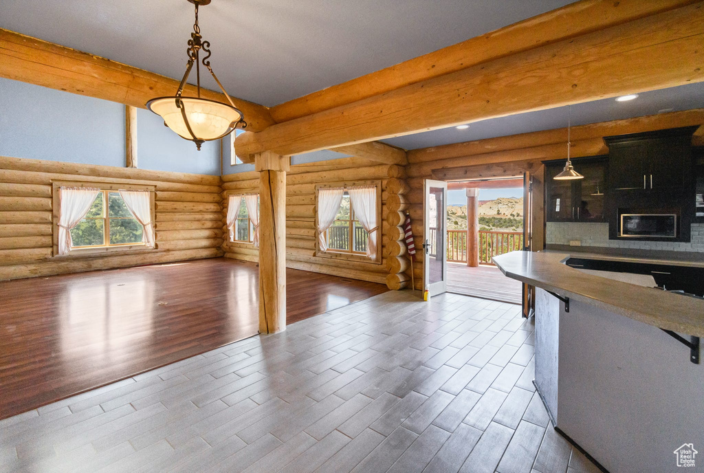Kitchen with dark cabinets, open floor plan, decorative light fixtures, and dark wood-type flooring