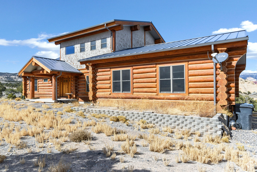Exterior space featuring metal roof, a standing seam roof, and log siding