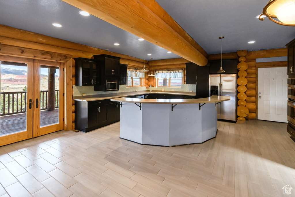 Kitchen with a kitchen island, appliances with stainless steel finishes, a breakfast bar area, decorative light fixtures, and recessed lighting