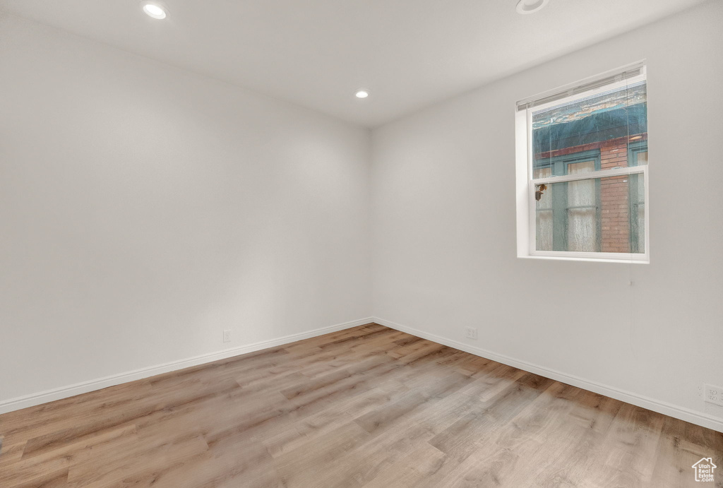 Empty room with hardwood / wood-style flooring