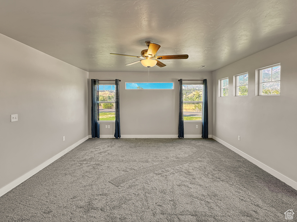 Empty room with ceiling fan and carpet floors