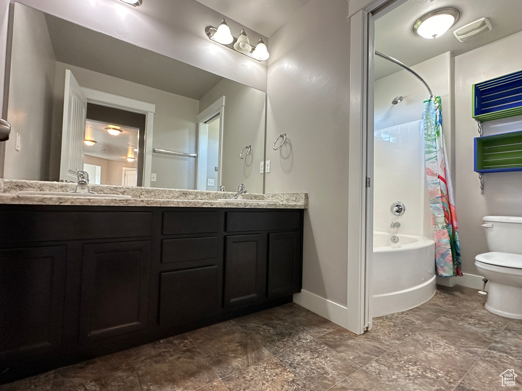 Full bathroom featuring vanity, shower / tub combo, and toilet