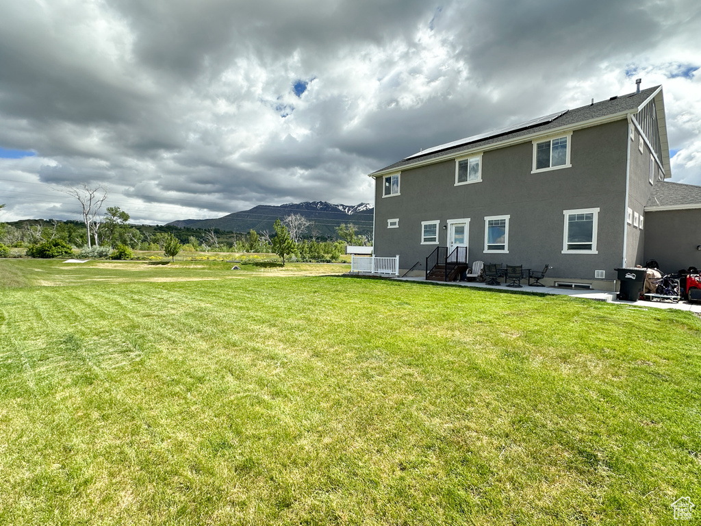 Rear view of property featuring a patio area and a lawn