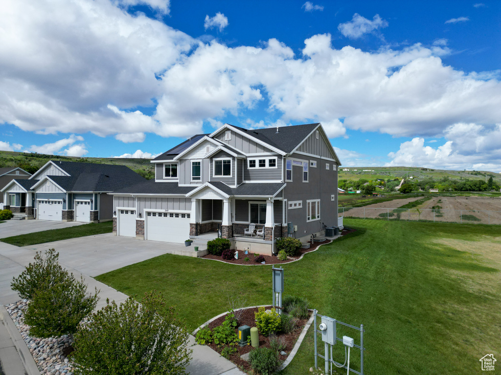 Craftsman-style house with a front lawn, a garage, and a porch