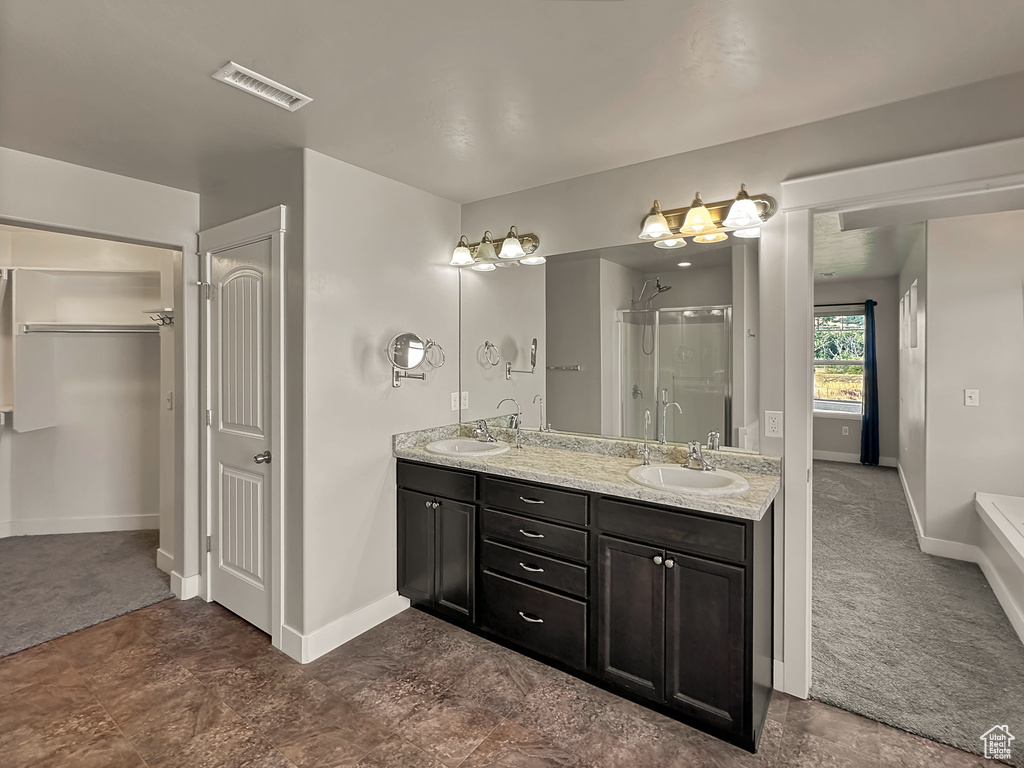 Bathroom featuring shower with separate bathtub and vanity