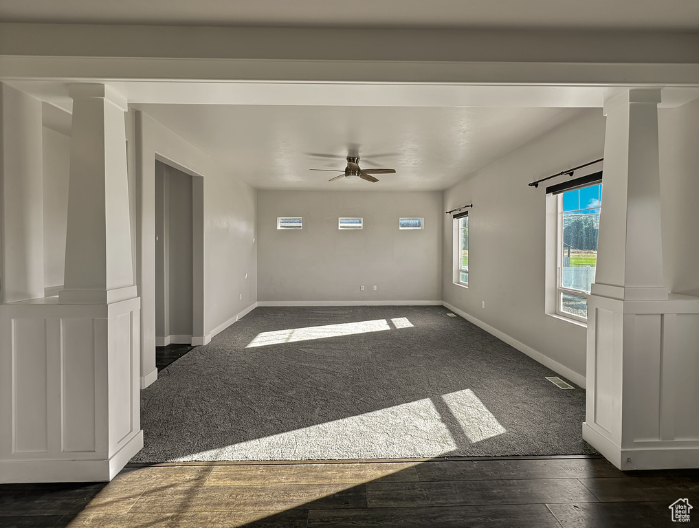 Unfurnished room featuring ceiling fan and dark colored carpet