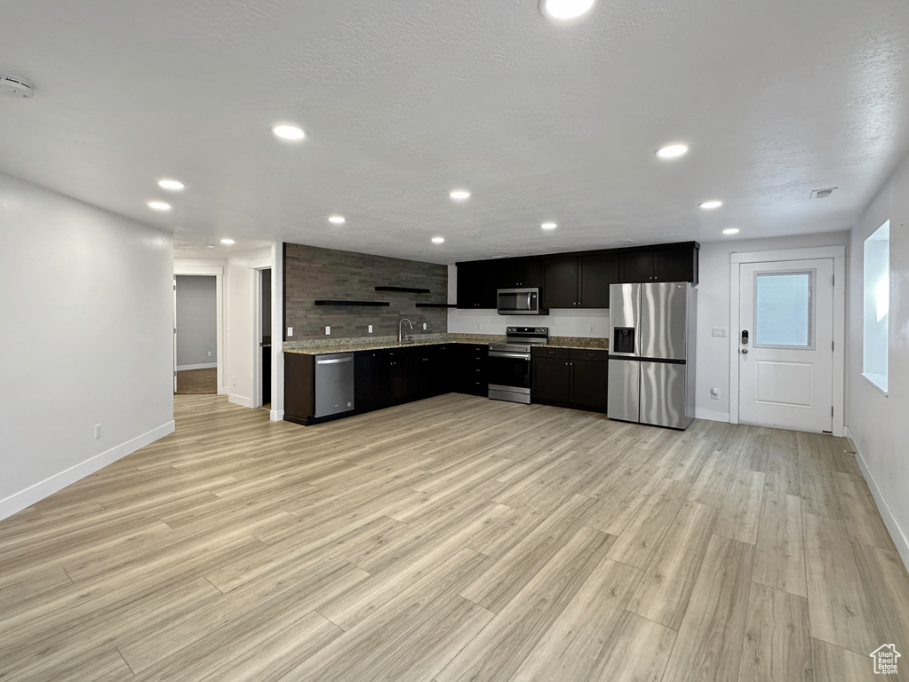 Kitchen featuring stainless steel appliances, light hardwood / wood-style floors, and sink