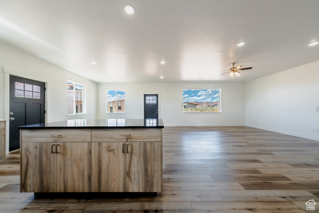 Kitchen with ceiling fan, light brown cabinets, and hardwood / wood-style flooring