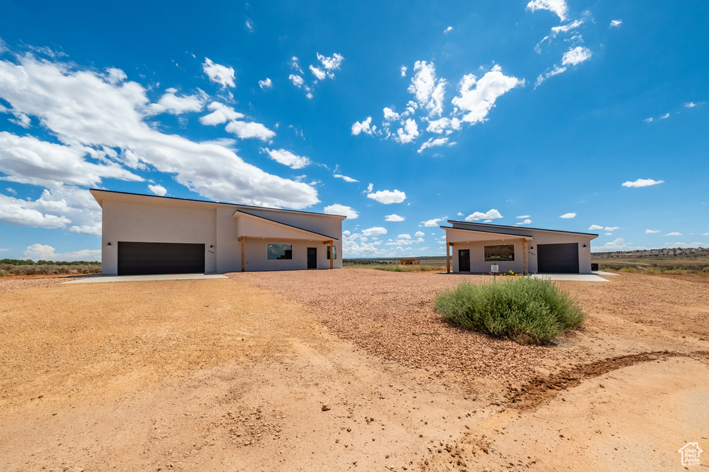 View of side of home with a garage and a rural view