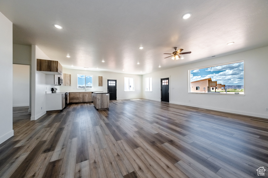 Unfurnished living room with ceiling fan and dark hardwood / wood-style flooring