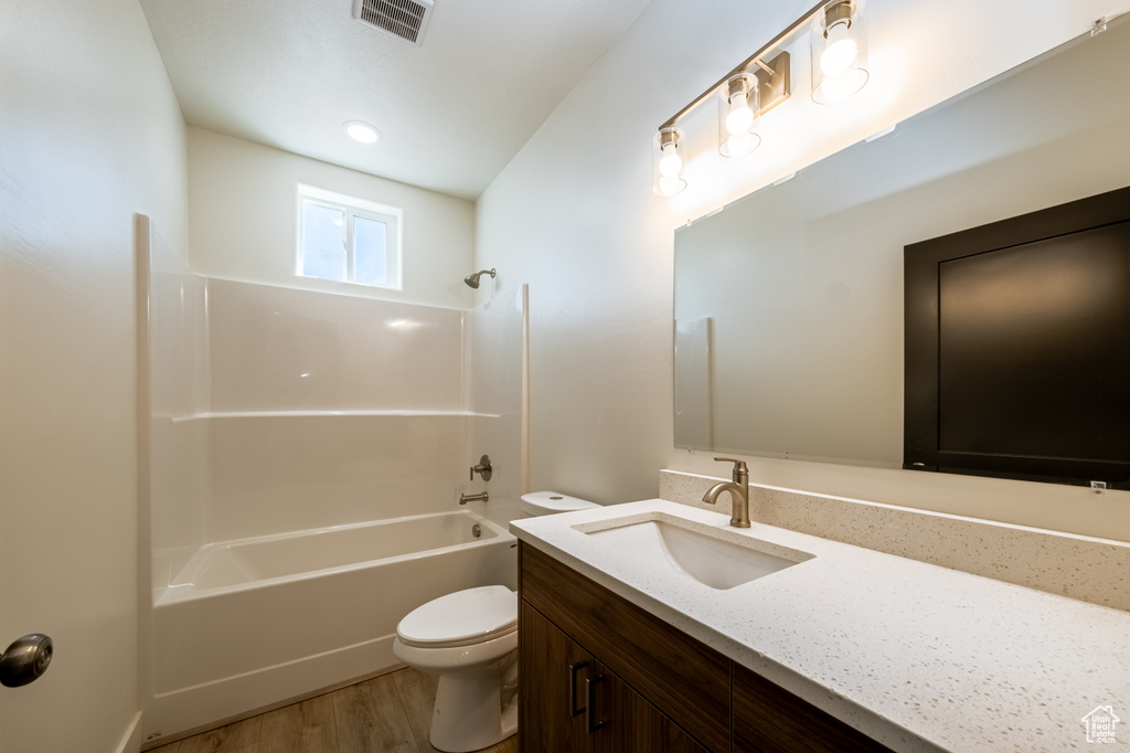 Full bathroom featuring tub / shower combination, vanity, toilet, and wood-type flooring