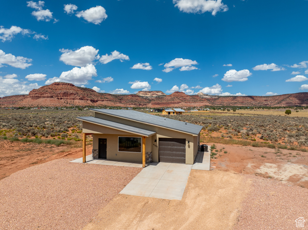 View of front of home with a mountain view and a garage