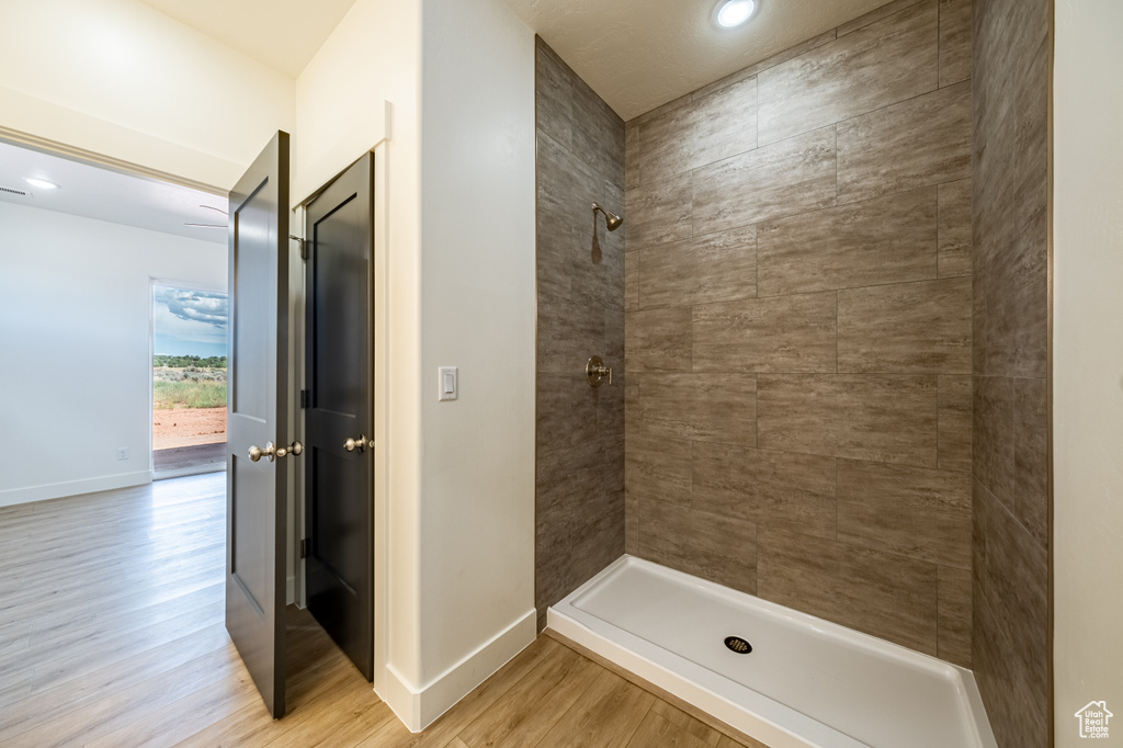 Bathroom featuring hardwood / wood-style floors and tiled shower