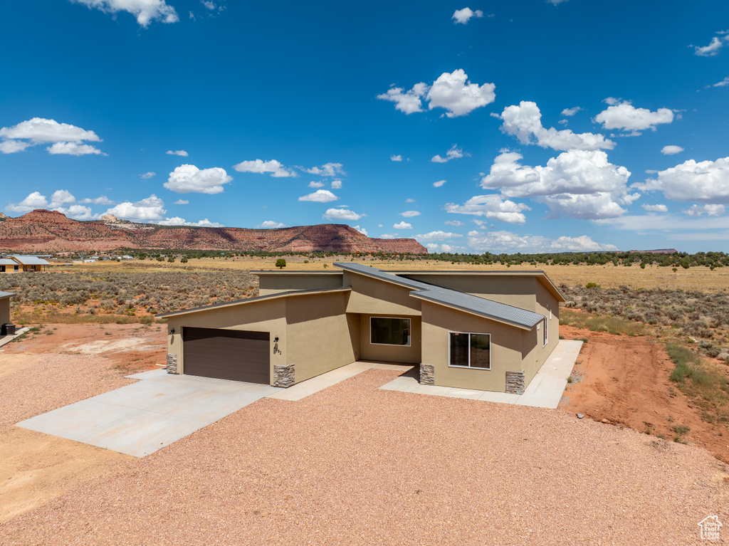 View of front of property with a mountain view and a garage