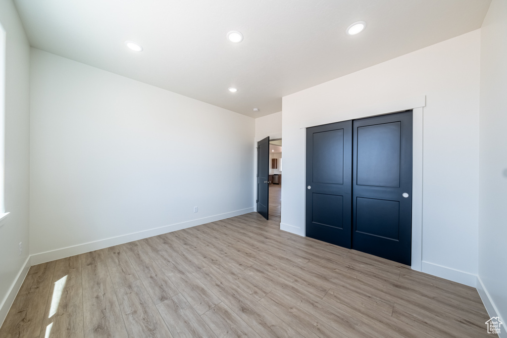 Unfurnished bedroom featuring a closet and light hardwood / wood-style flooring