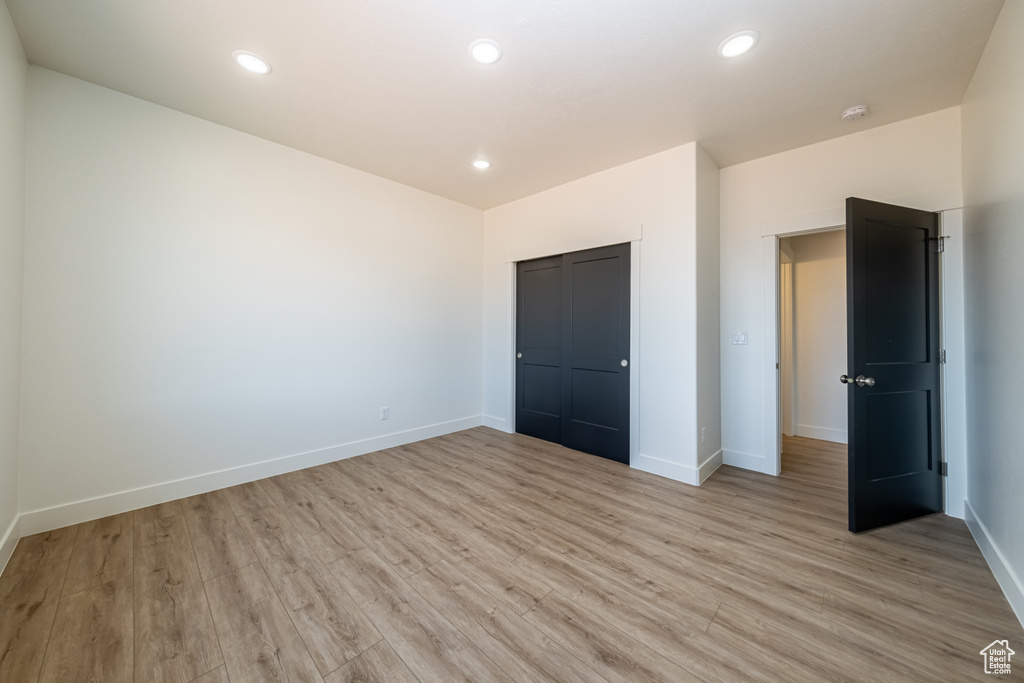 Unfurnished bedroom featuring a closet and light hardwood / wood-style floors