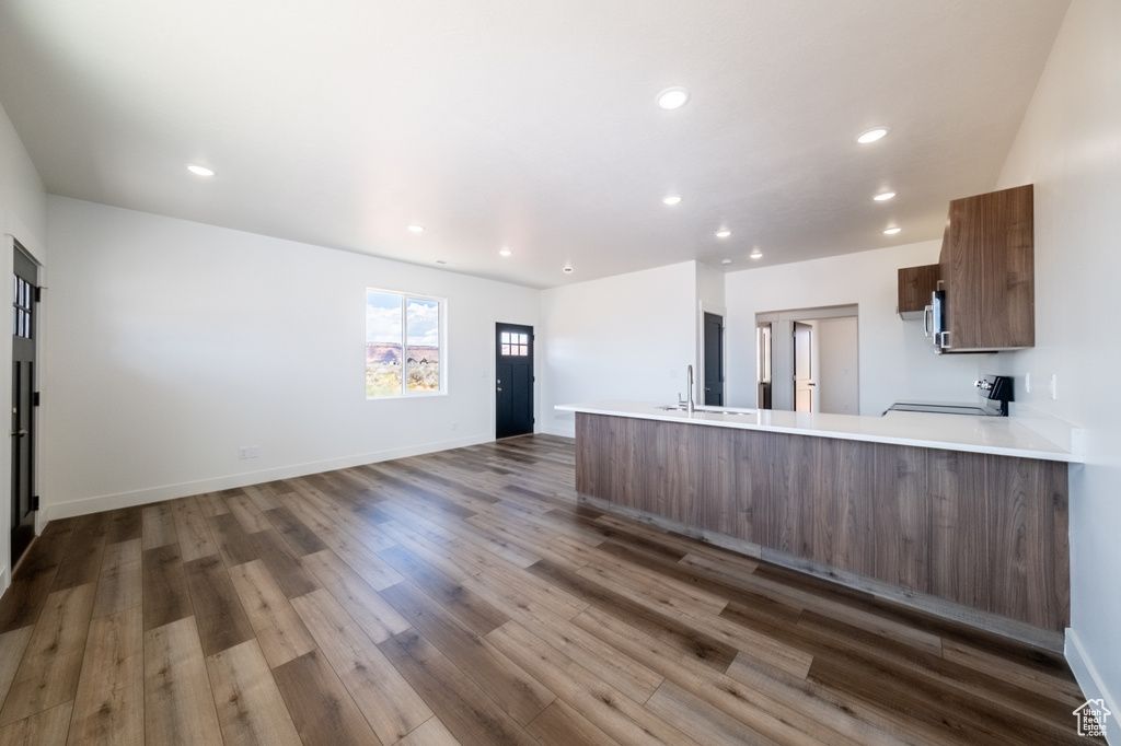 Kitchen featuring kitchen peninsula, sink, hardwood / wood-style floors, and stove