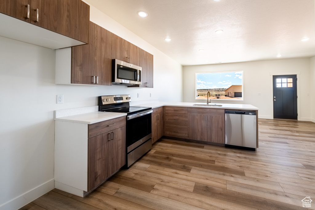 Kitchen with plenty of natural light, light wood-type flooring, sink, and appliances with stainless steel finishes