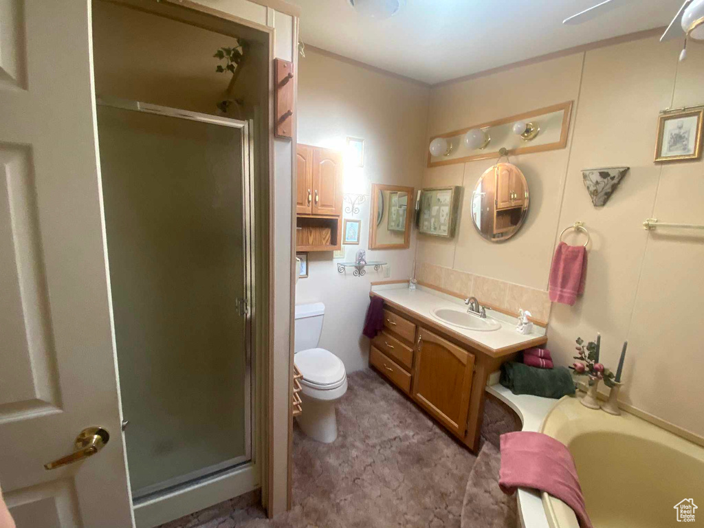 Full bathroom with shower with separate bathtub, toilet, and vanity