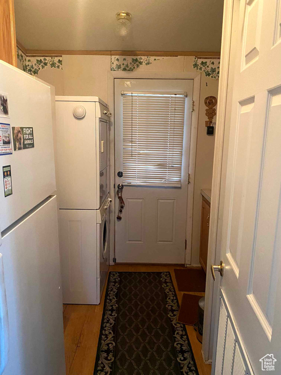 Doorway to outside featuring stacked washer and dryer and hardwood / wood-style flooring