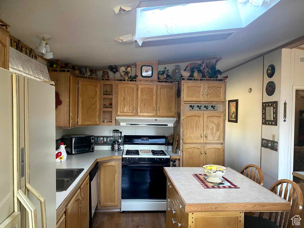 Kitchen featuring sink, dark hardwood / wood-style flooring, white appliances, and tile countertops