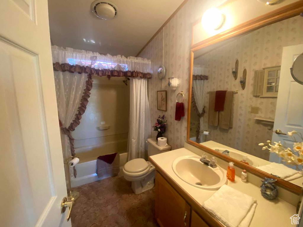 Full bathroom with toilet, shower / tub combo with curtain, and oversized vanity