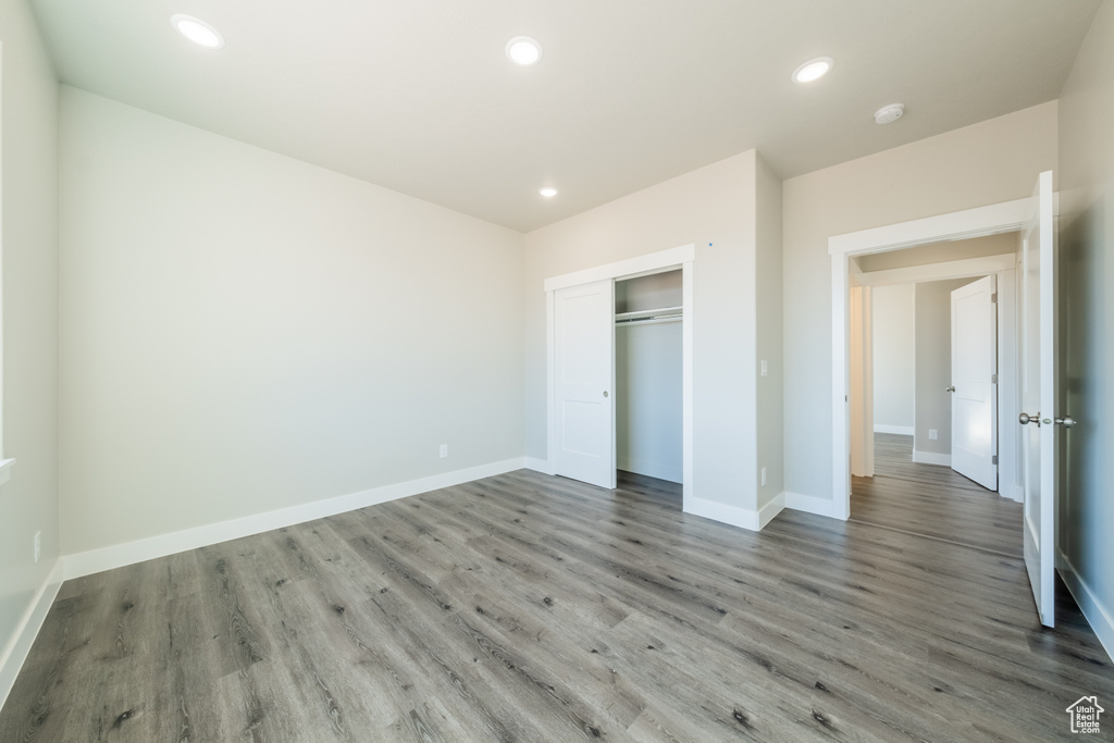 Unfurnished bedroom with a closet and hardwood / wood-style flooring