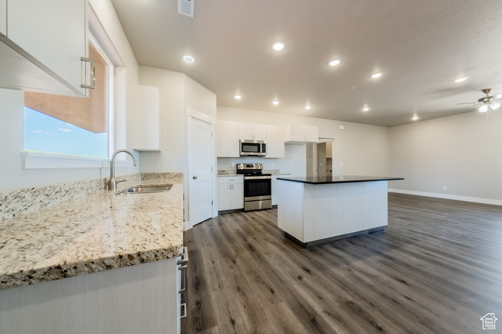 Kitchen with sink, white cabinetry, stainless steel appliances, dark hardwood / wood-style flooring, and ceiling fan