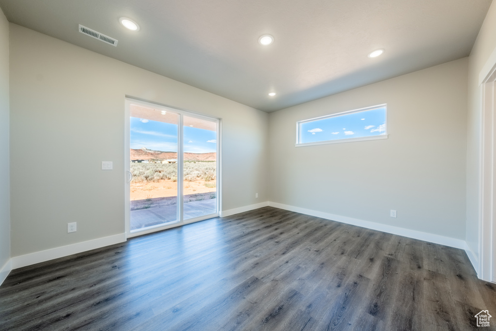 Empty room with dark hardwood / wood-style flooring