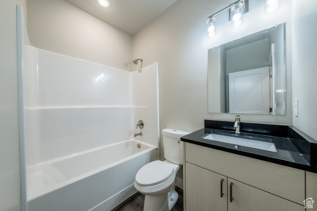 Full bathroom featuring tub / shower combination, vanity, hardwood / wood-style floors, and toilet