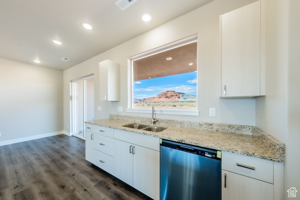 Kitchen featuring white cabinets, light stone countertops, stainless steel dishwasher, dark hardwood / wood-style floors, and sink