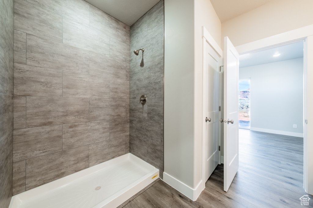 Bathroom with hardwood / wood-style floors and tiled shower