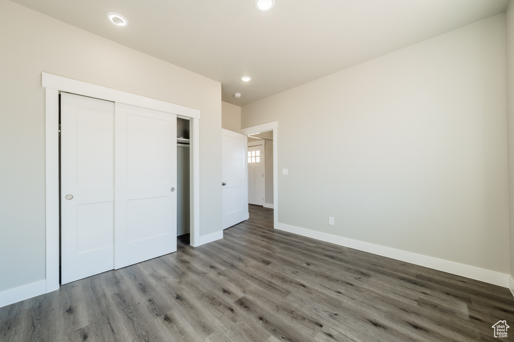 Unfurnished bedroom featuring wood-type flooring and a closet