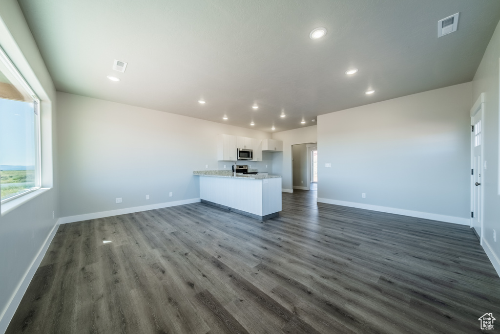 Unfurnished living room featuring dark hardwood / wood-style flooring