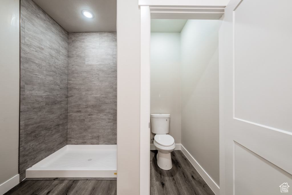 Bathroom with walk in shower, hardwood / wood-style floors, and toilet