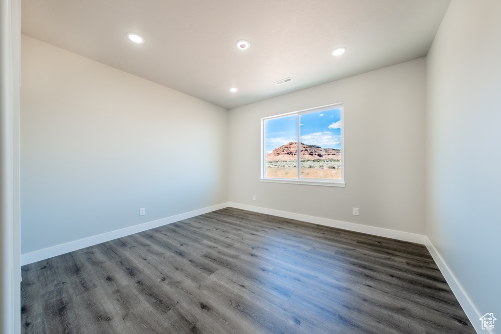 Empty room with dark wood-type flooring