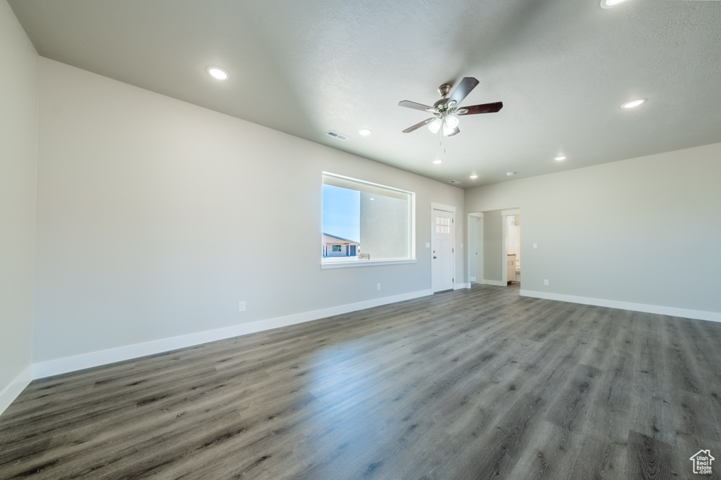 Unfurnished living room with ceiling fan and hardwood / wood-style flooring