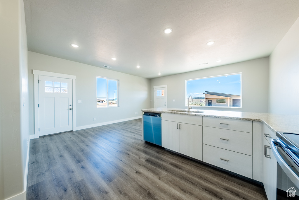 Kitchen with sink, dark wood-type flooring, stainless steel appliances, and white cabinets