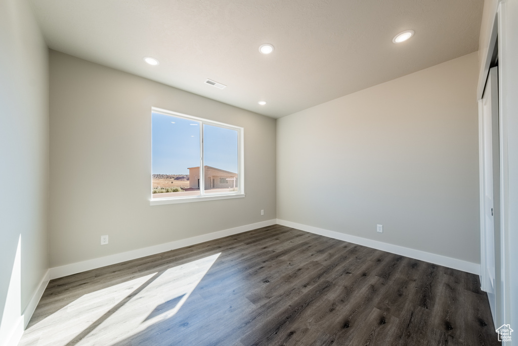 Empty room with dark hardwood / wood-style flooring