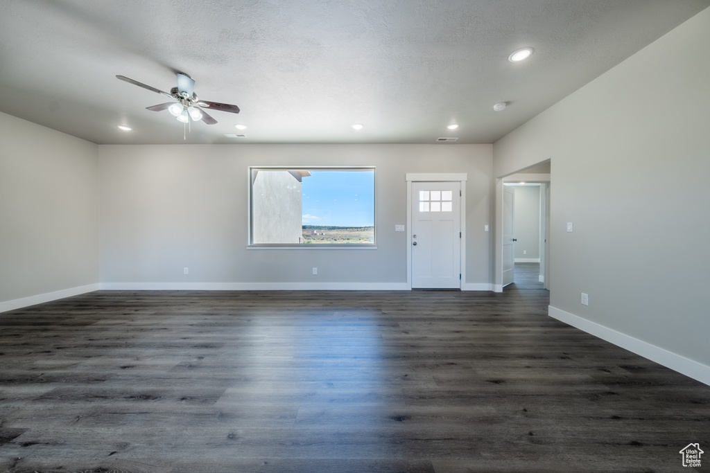 Interior space featuring ceiling fan, dark hardwood / wood-style floors, and a textured ceiling