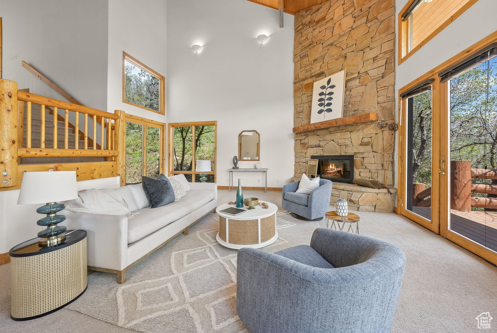 Living room featuring a high ceiling, a fireplace, and carpet