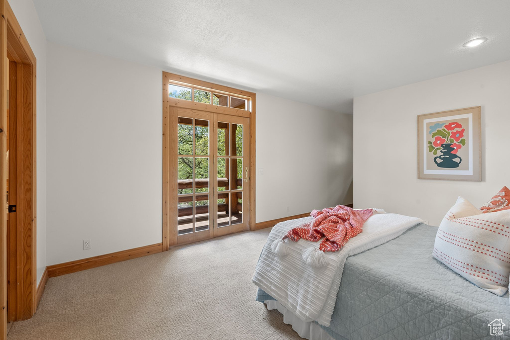 Carpeted bedroom featuring access to outside and french doors