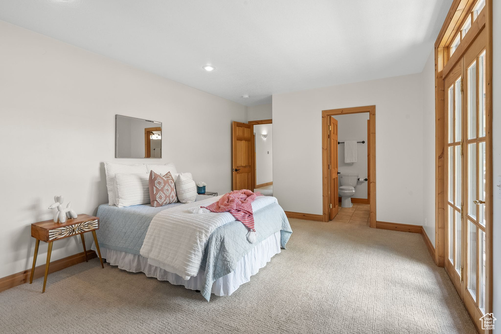 Carpeted bedroom featuring ensuite bath