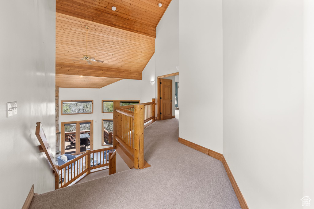 Corridor featuring high vaulted ceiling, carpet flooring, and wooden ceiling