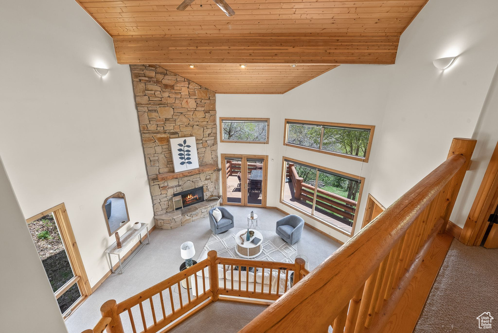 Living room featuring a wealth of natural light, high vaulted ceiling, and carpet floors