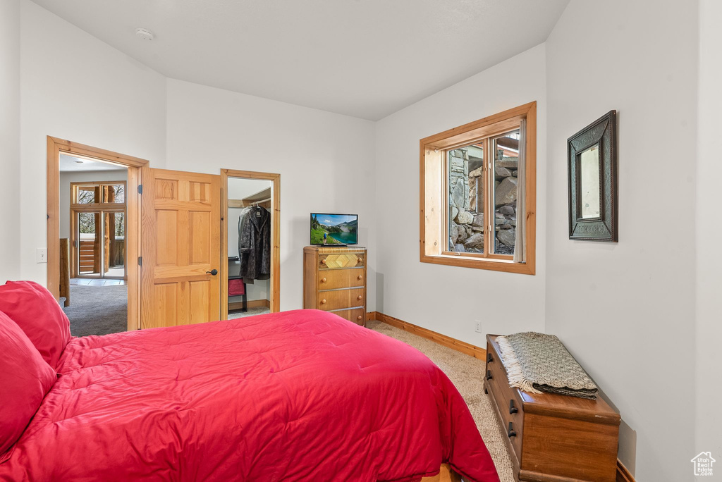 Carpeted bedroom with a spacious closet and a closet