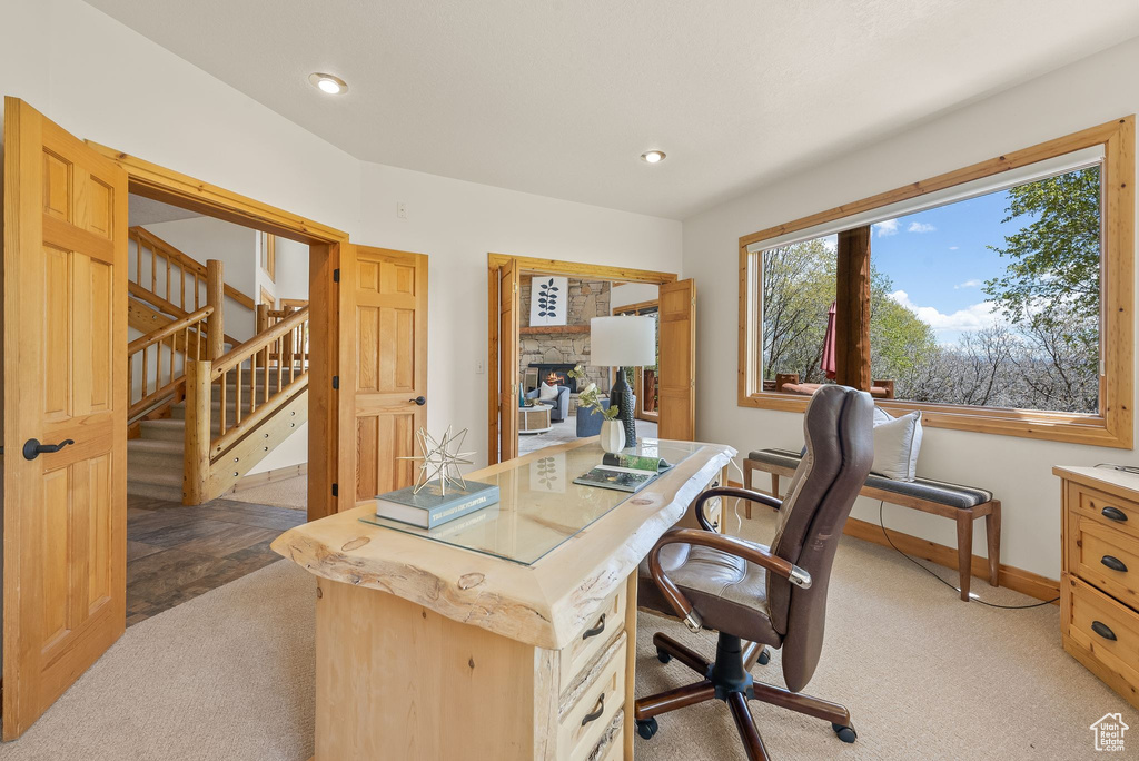 Carpeted office space featuring a fireplace