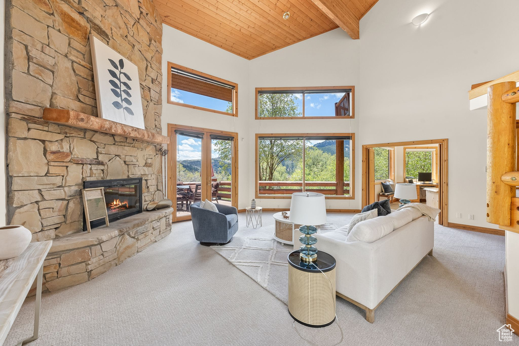 Living room with high vaulted ceiling, beamed ceiling, carpet, and wood ceiling