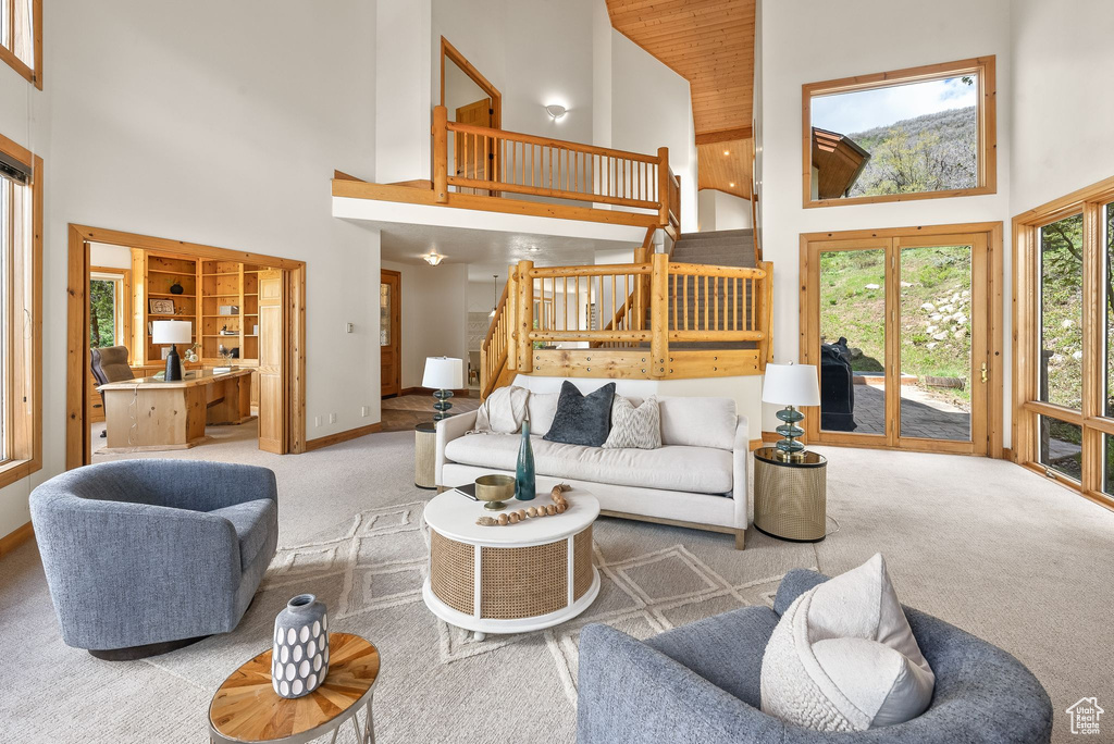 Carpeted living room featuring a towering ceiling