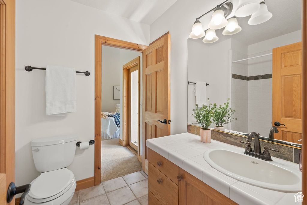 Bathroom with tile flooring, vanity, and toilet